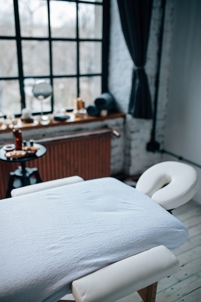 Sala de massagem organizada e confortável Sala de massagem organizada com maca e ambiente confortável